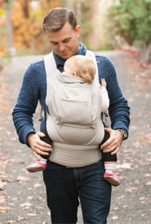 Man carrying baby in an Onya Baby Carrier in the front carry position.
